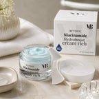 Geöffneter Tiegel der MOnB Retinol Niacinamide Hydroboost Cream Rich mit hellblauer Creme und Spatel für intensive Pflege und Feuchtigkeit